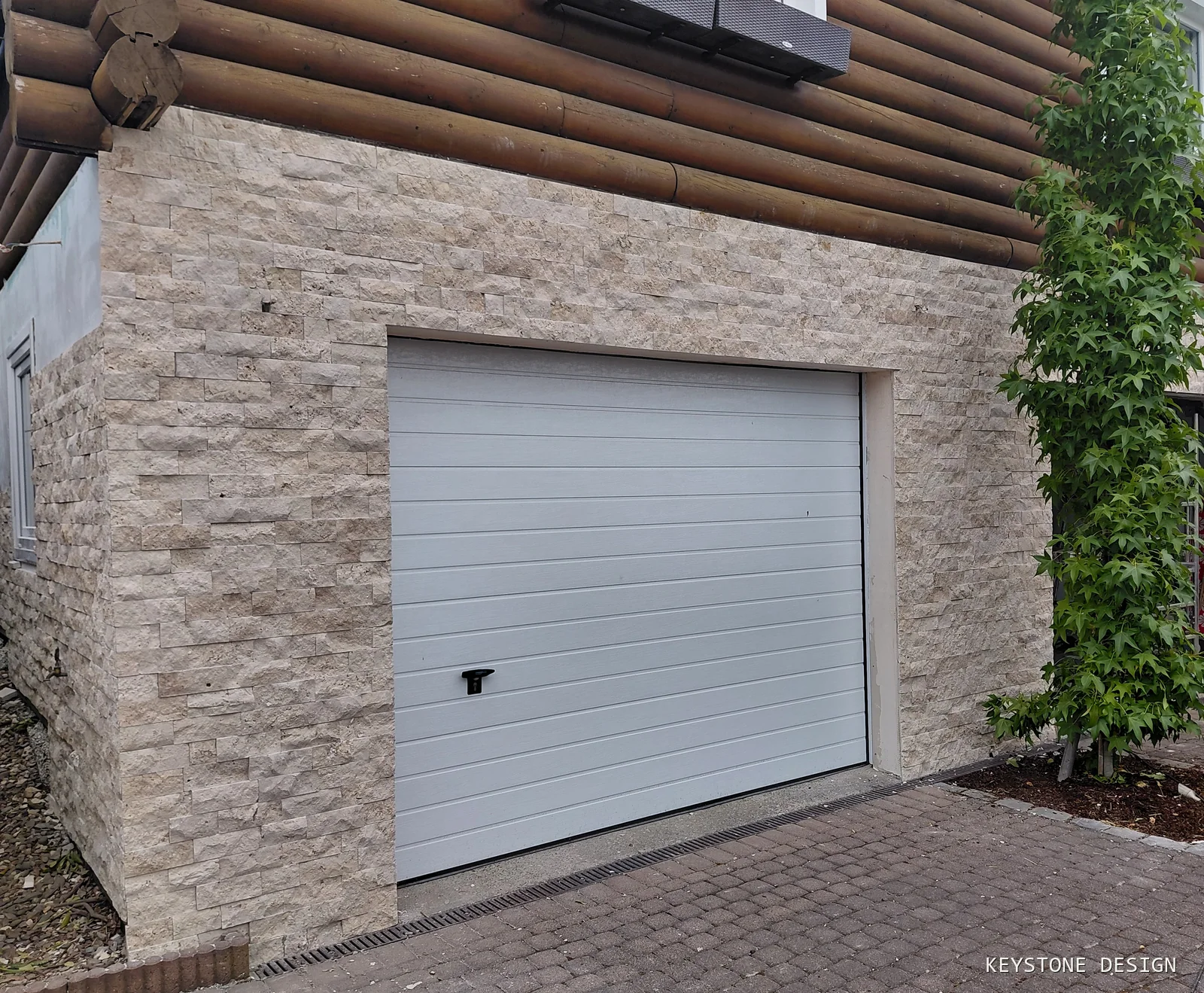 Neuer Natursteinsockel unter der erhaltenen Blockholzfassade